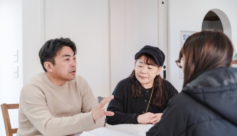 女性が男性と女性にパソコンを使用して説明している写真